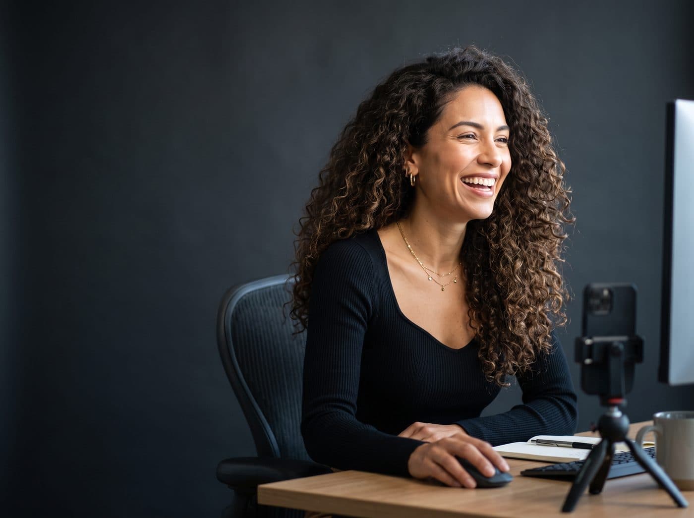 Sagum strategist laughing at her desk while working